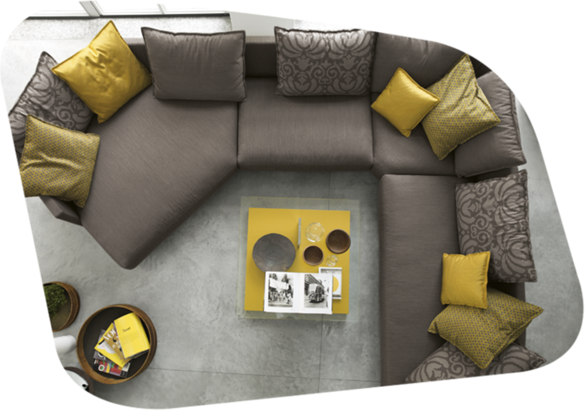 dunkle Couch in U Form und mit gelb gemusterten Kissen