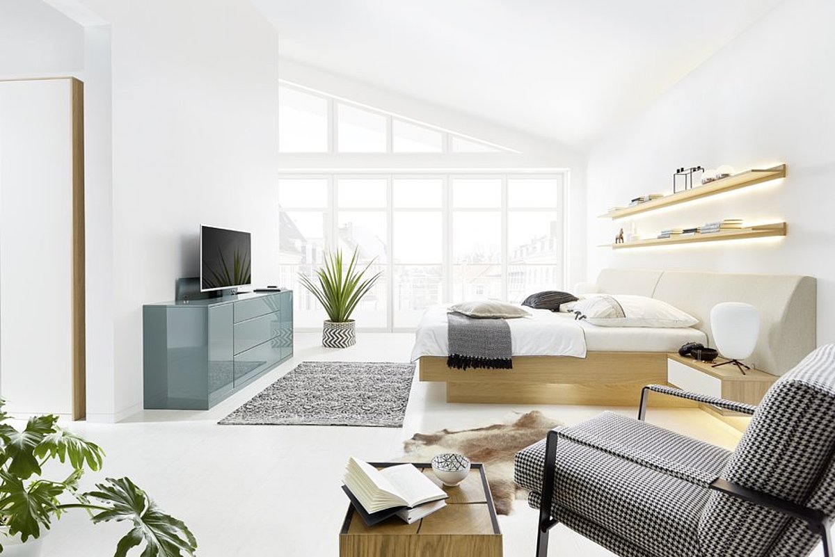 SChlafzimmer mit Lack grünem Sideboard und ausgefahrenem Fernseher