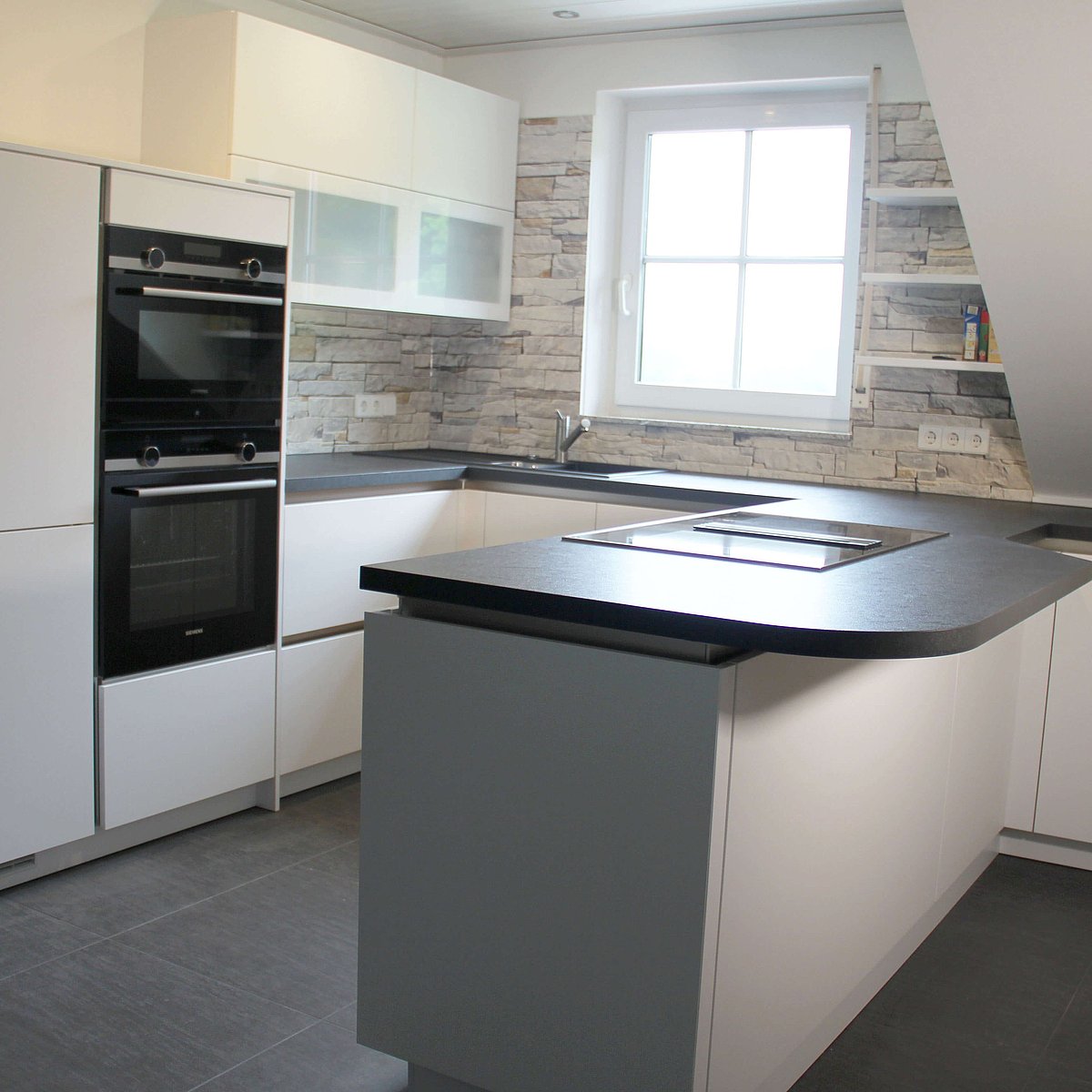 Küche in weiß mit Oberschränken mit Glasfront, Backofen und Halbinsel