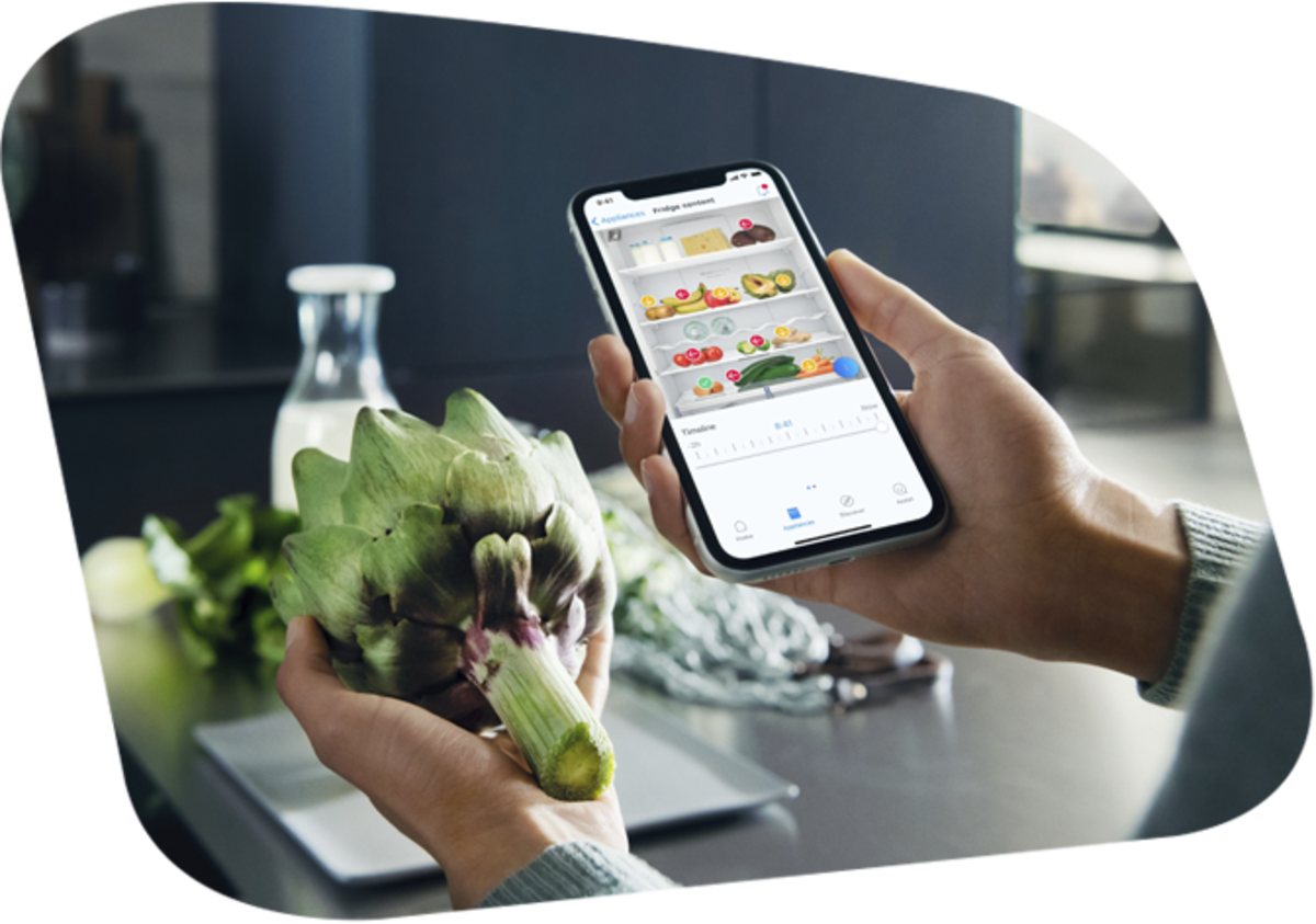 Smartphone in der Hand einer Person vor Lebensmitteln