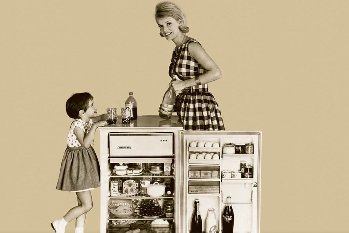 Frau und Kind mit geöffneten Kühlschrank