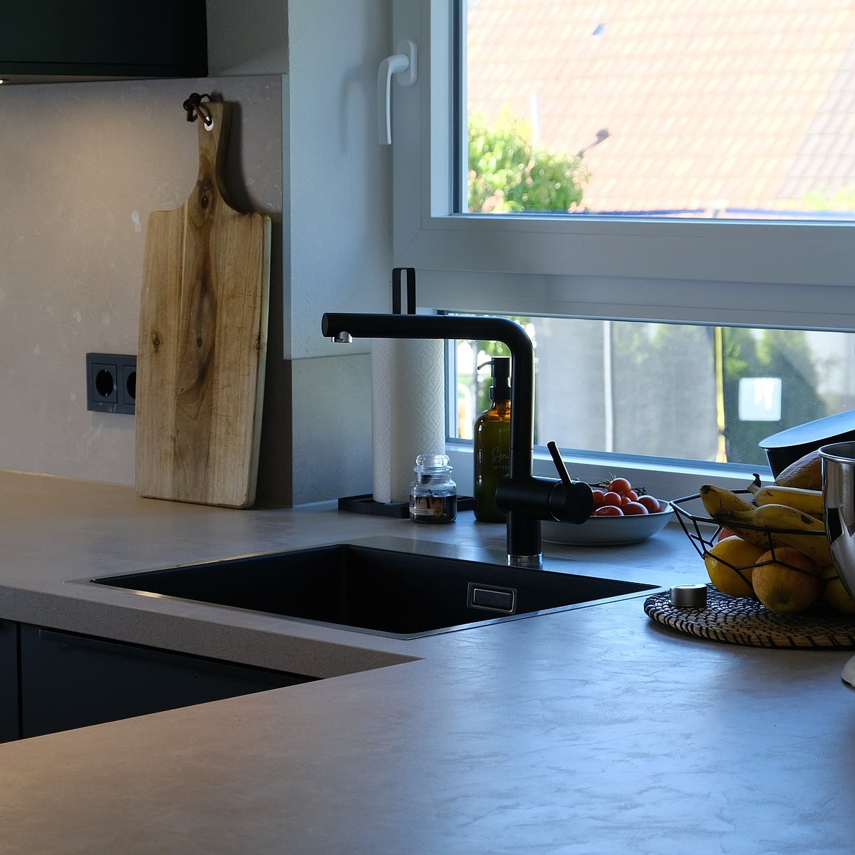 Dunkle Küche mit heller Stein-Arbeitsplatte